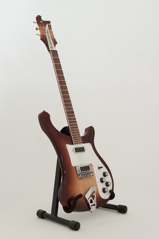 A brown and white electric guitar on a stand