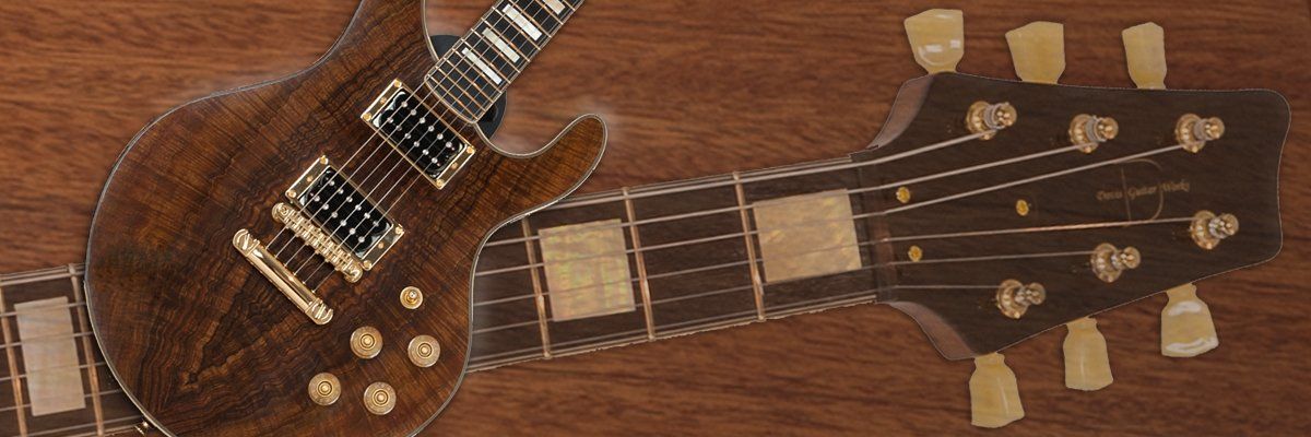Two guitars are sitting on a wooden table.