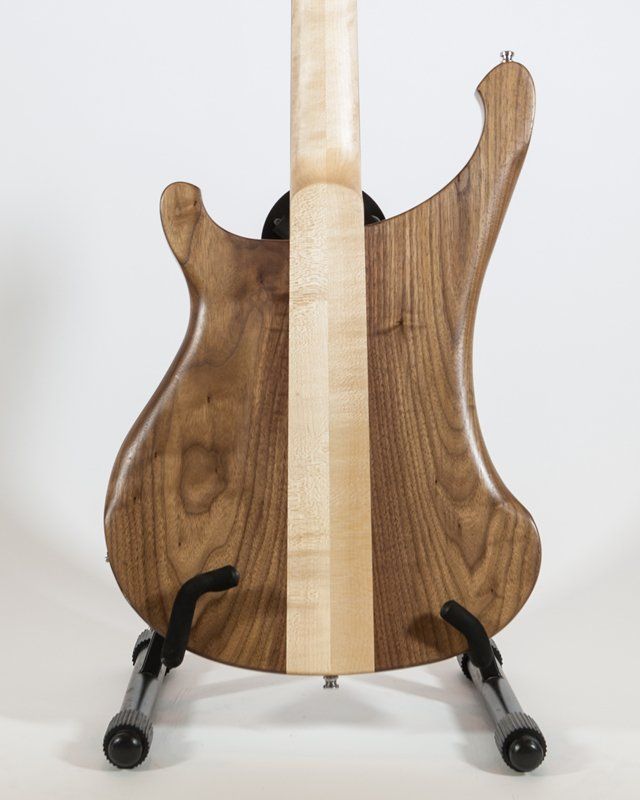 The back of a guitar is shown on a stand