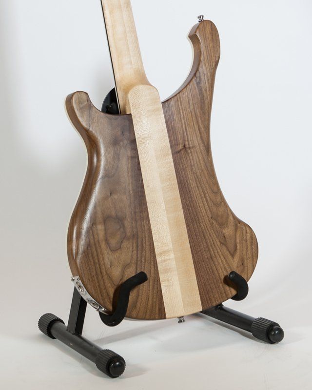 The back of a guitar is shown on a stand