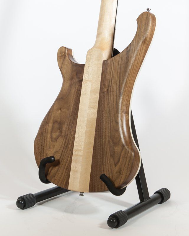 The back of a guitar is shown on a stand