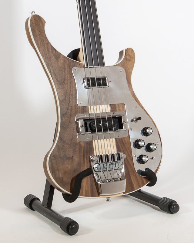 A bass guitar is sitting on a stand on a white background