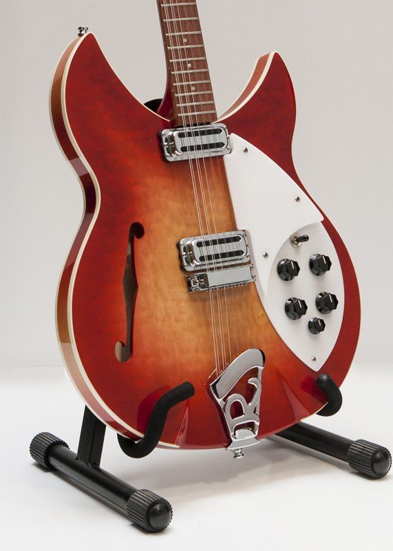 A rickenbacker guitar is sitting on a stand