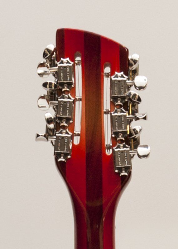 A close up of the headstock of a red guitar