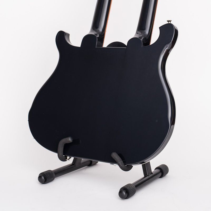 A black guitar is sitting on a black stand