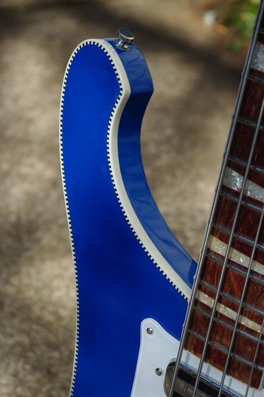 A blue electric guitar is sitting on the ground