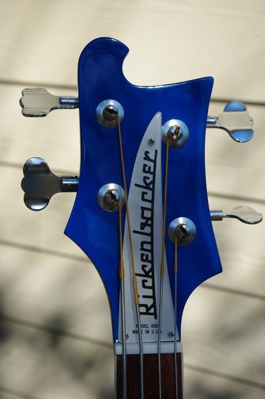 The headstock of a blue rickenbacker bass guitar
