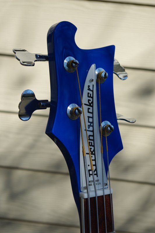 The headstock of a blue rickenbacker bass guitar