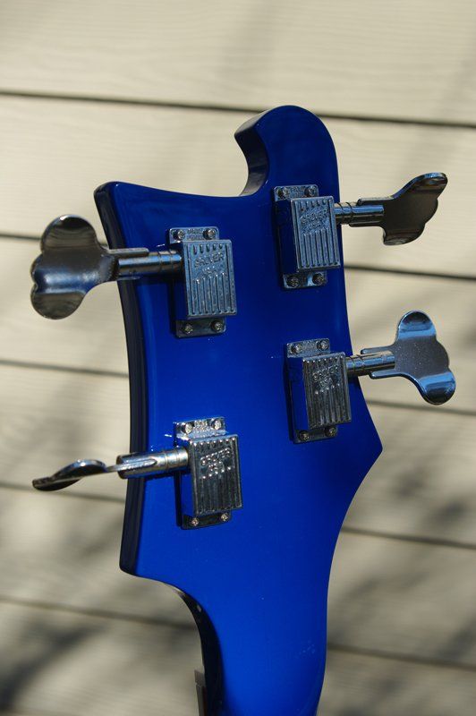 The back of a blue bass guitar is shown