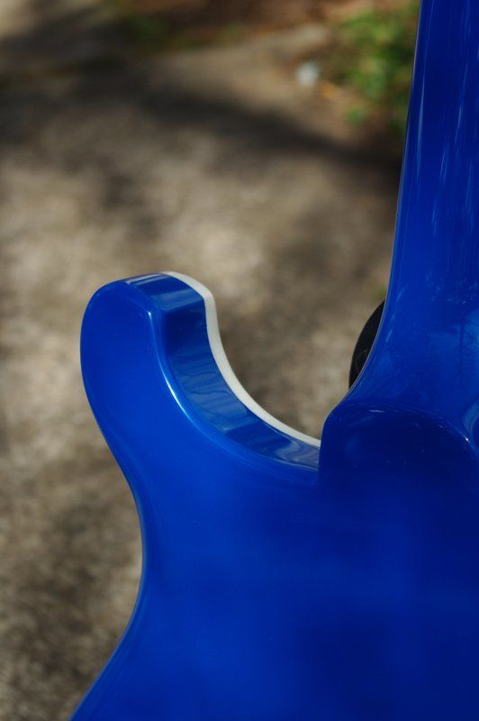 A close up of the back of a blue electric guitar.