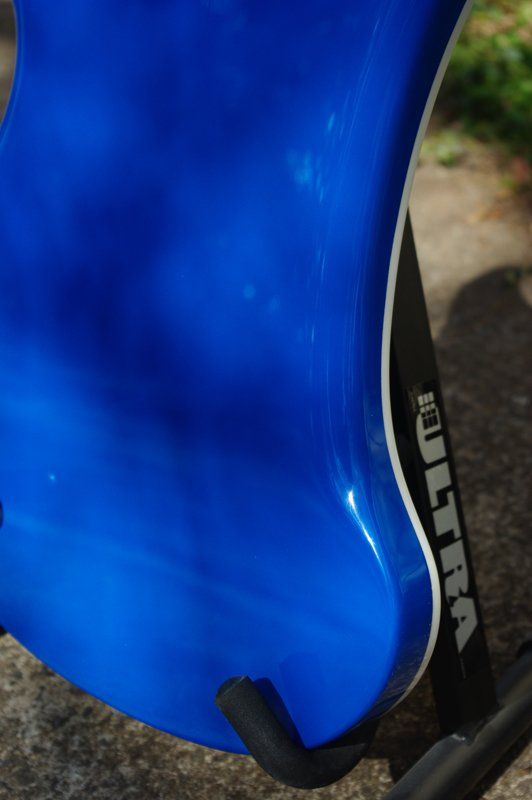 A blue guitar is sitting on a stand that says ultra