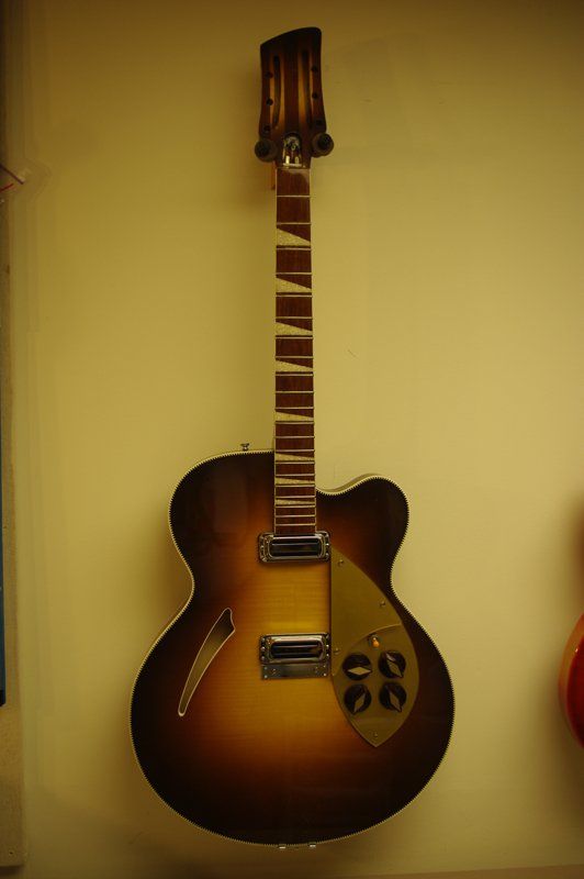 A guitar is hanging on a wall with a broken neck