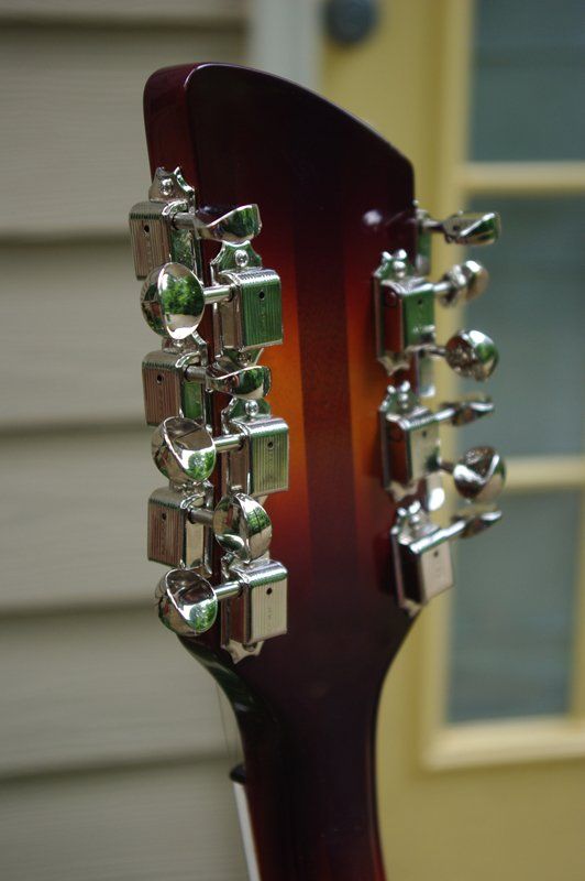A close up of a guitar headstock with chrome tuners