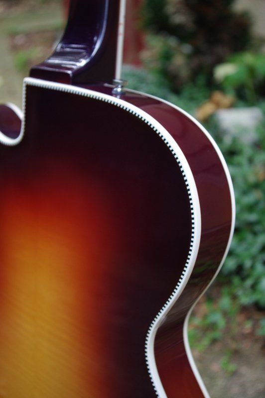 The back of a guitar is shown in a close up.