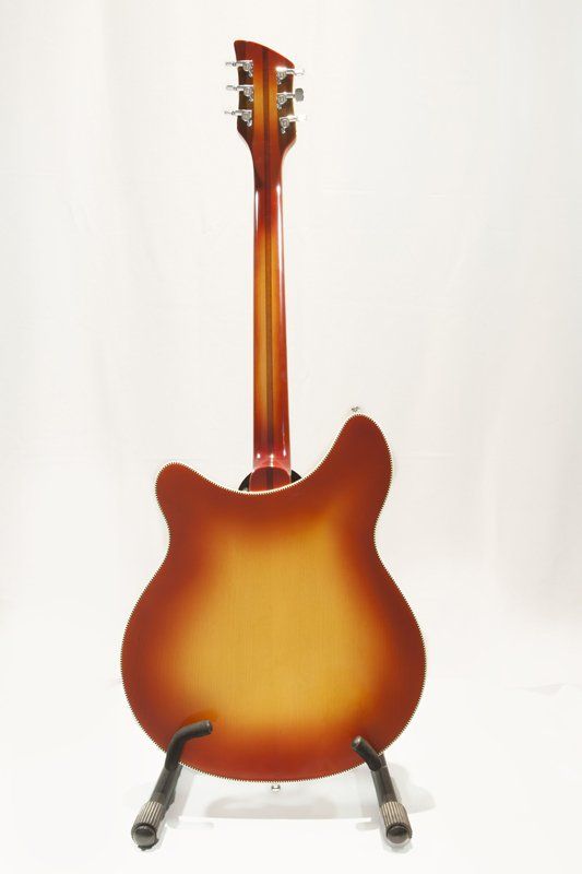 A guitar is sitting on a stand on a white background.