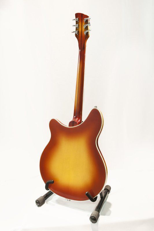 A guitar is sitting on a stand on a white background.