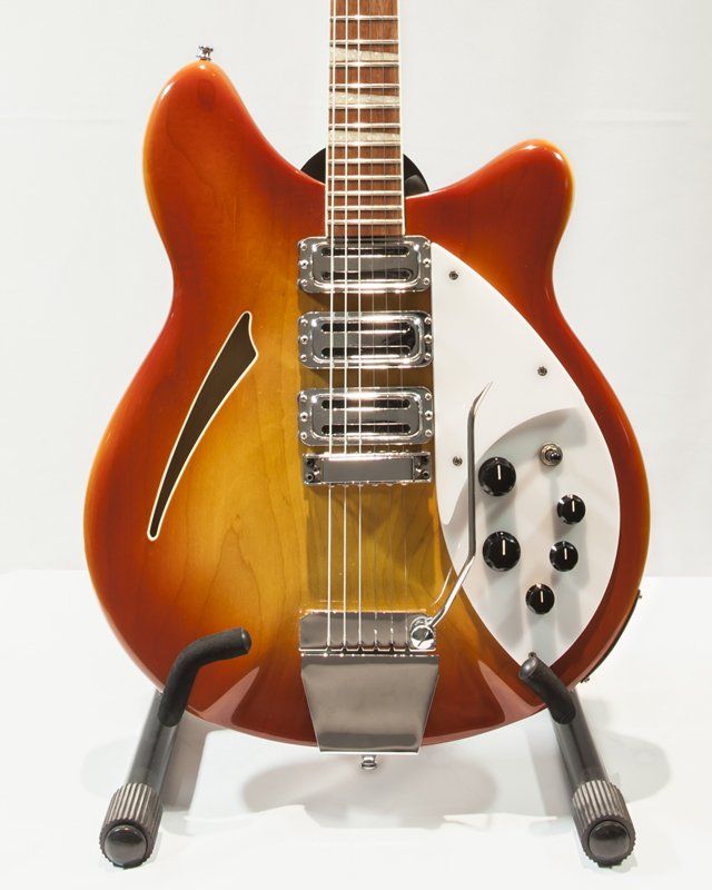 A guitar is sitting on a stand with a white background