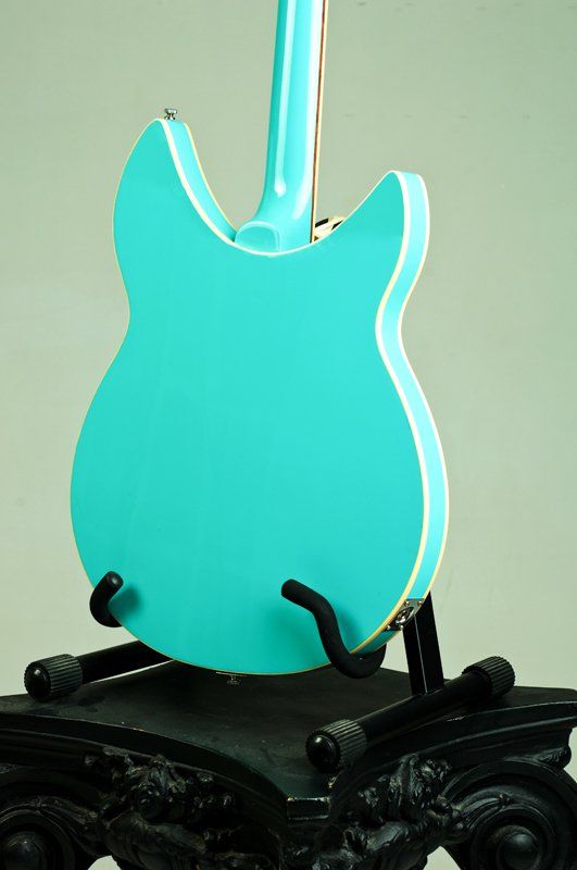 A blue guitar is sitting on a black stand