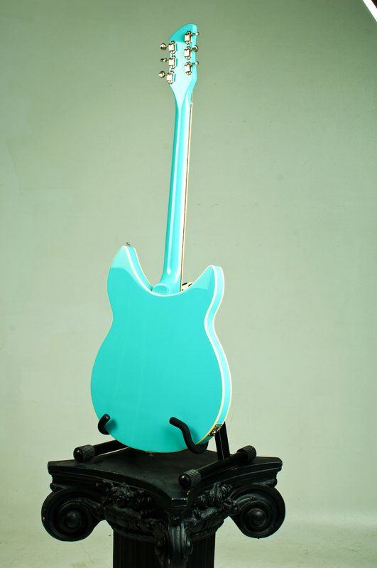 A blue guitar is sitting on top of a black pedestal.