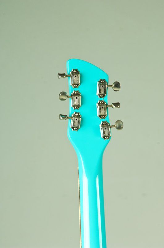 A close up of the headstock of a blue guitar