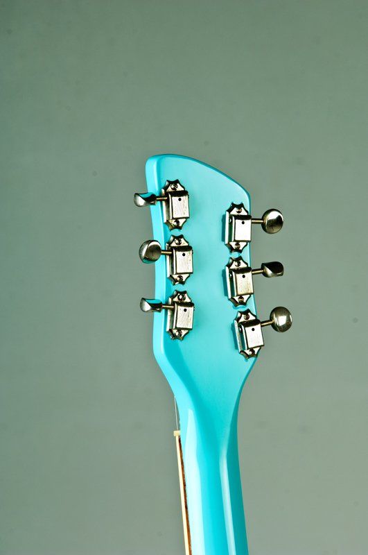 A close up of the headstock of a blue guitar
