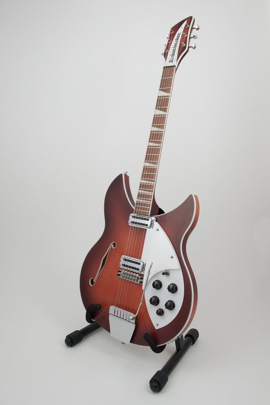 A guitar is sitting on a stand on a white background