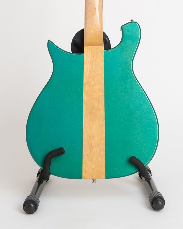 The back of a green guitar on a stand