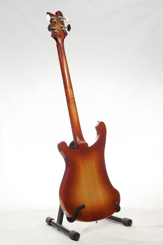 A guitar is sitting on a stand on a white background.