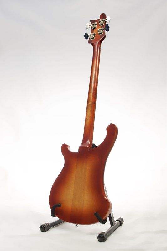 A guitar is sitting on a stand on a white background.