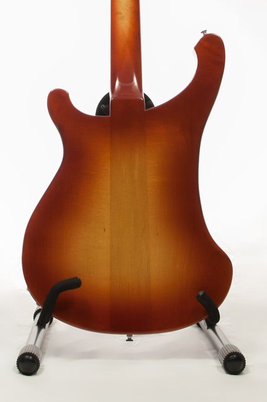 The back of a guitar is shown on a stand