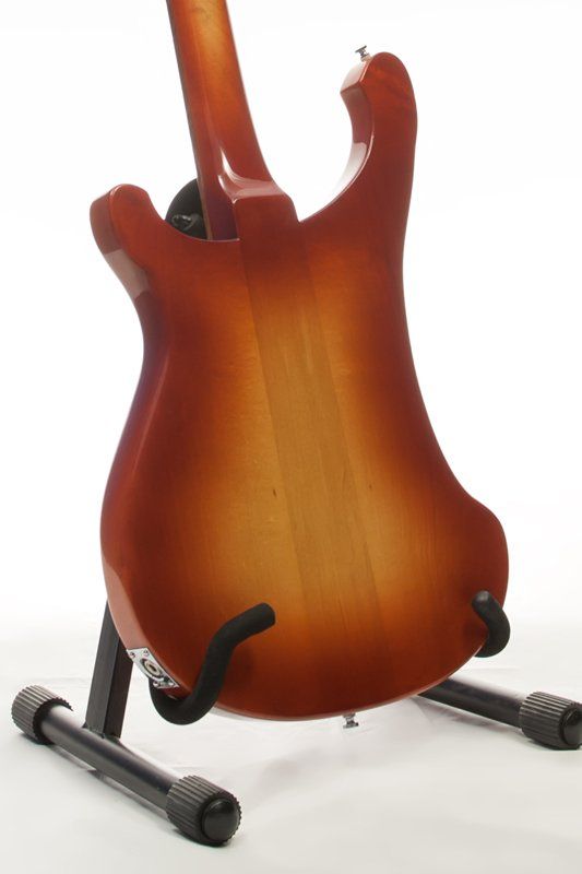 The back of a guitar is shown on a stand