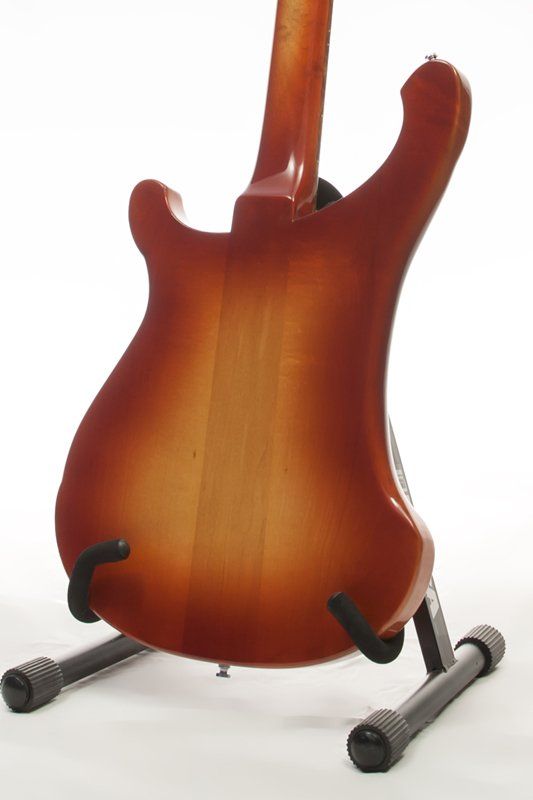 The back of a guitar is shown on a stand
