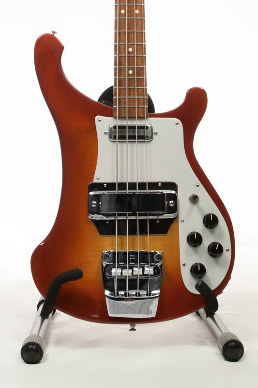 A bass guitar is sitting on a stand on a white background