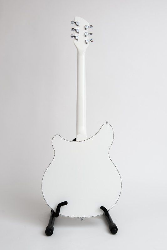 The back of a white electric guitar on a stand.