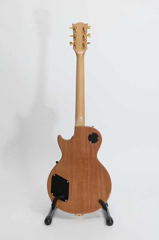 A guitar is sitting on a stand on a white background.