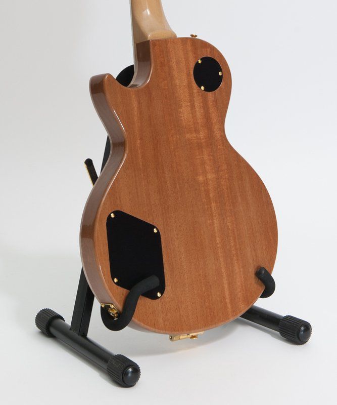 The back of a guitar is shown on a stand