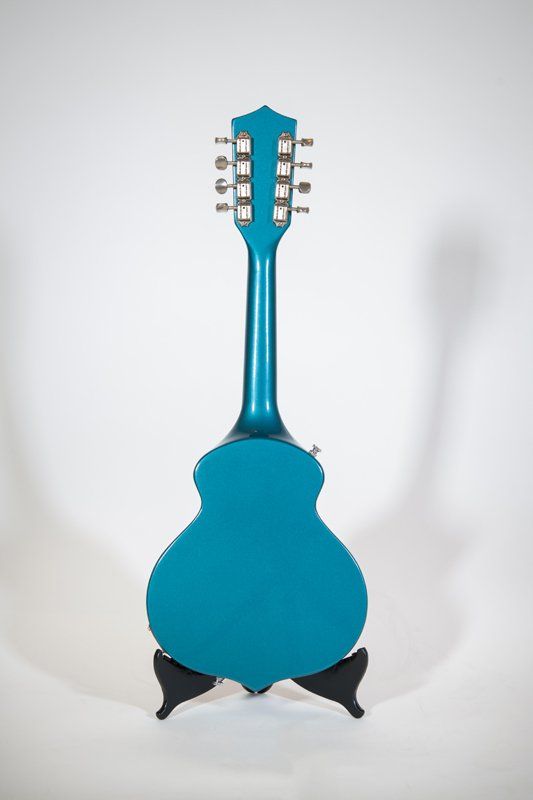 The back of a blue guitar is shown on a stand.