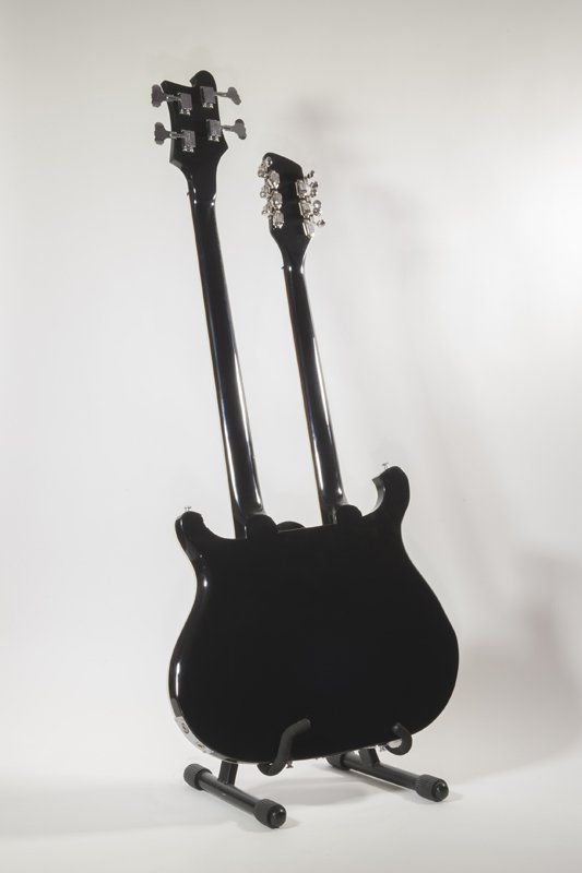 A guitar with two necks is sitting on a stand