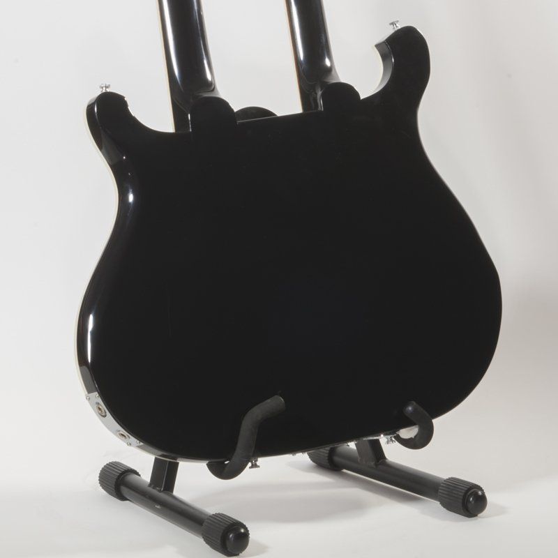 The back of a black guitar on a stand