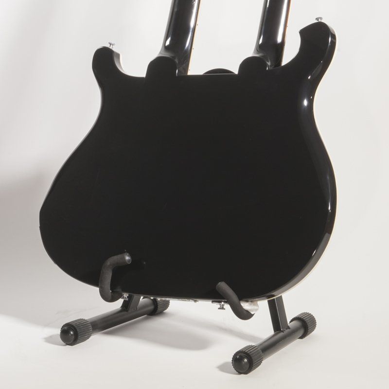 A black guitar is sitting on a black stand