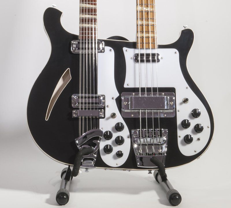 A double neck guitar is sitting on a stand