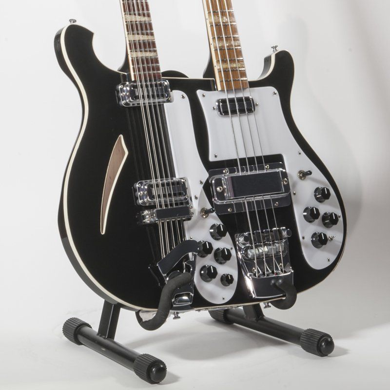 A double neck guitar is sitting on a stand