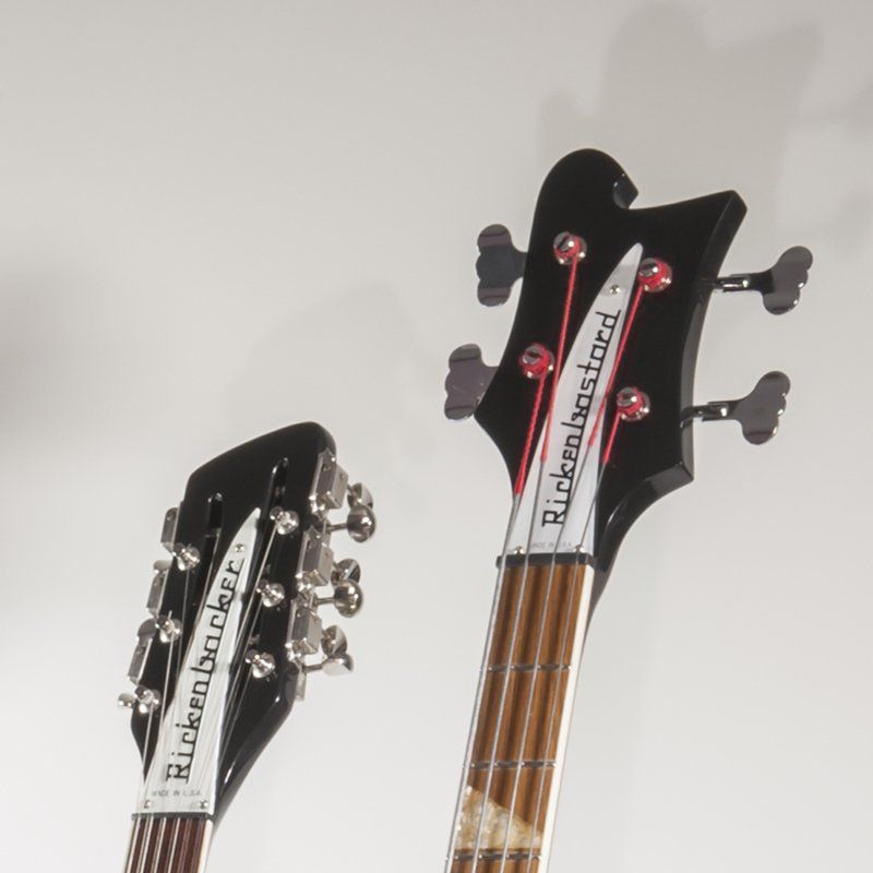 Two rickenbacker bass guitars against a white background