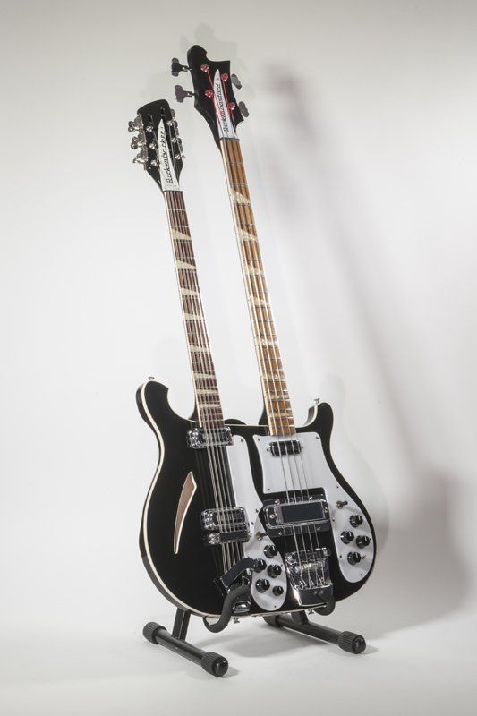 A double neck guitar is sitting on a stand