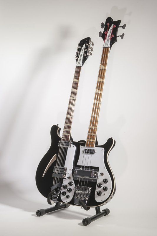 Two guitars are sitting on top of each other on a stand.