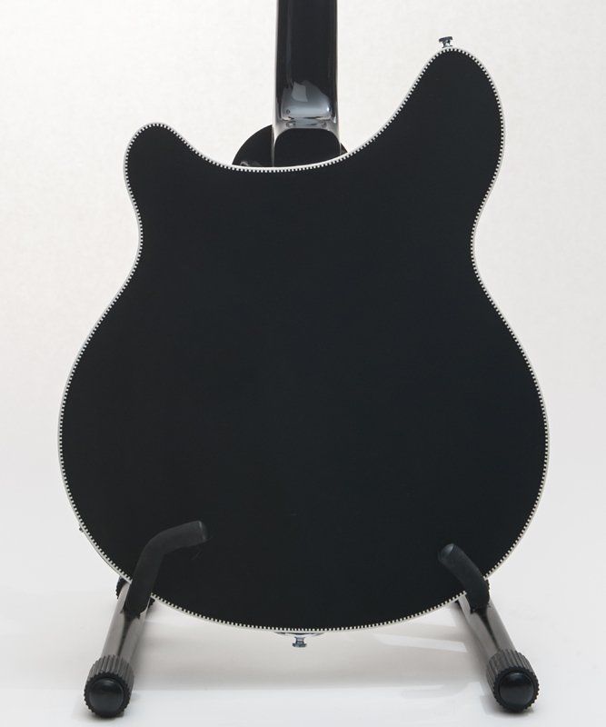 The back of a black guitar is shown on a stand