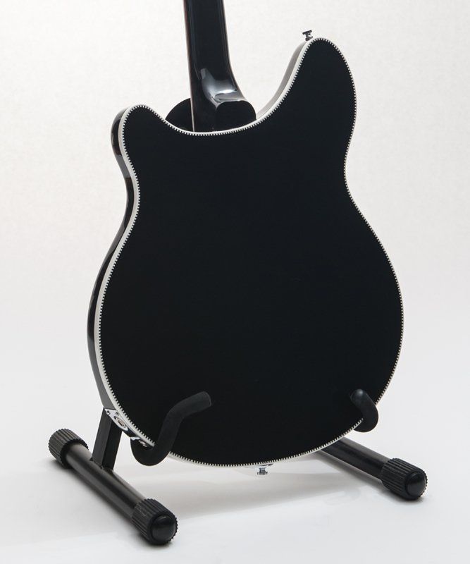 The back of a black guitar on a stand