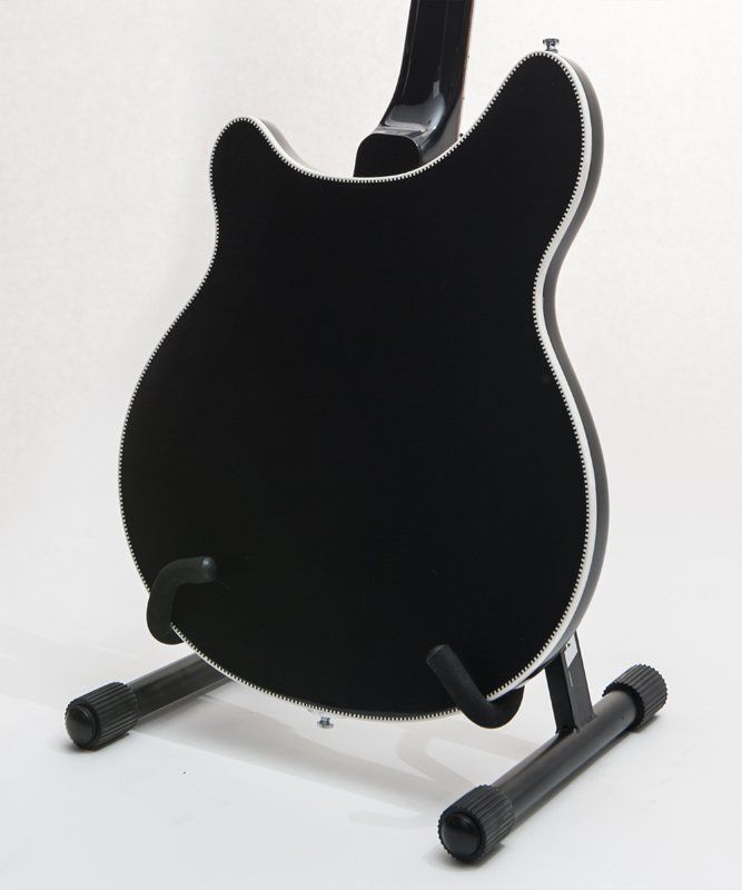 A black guitar is sitting on a black stand