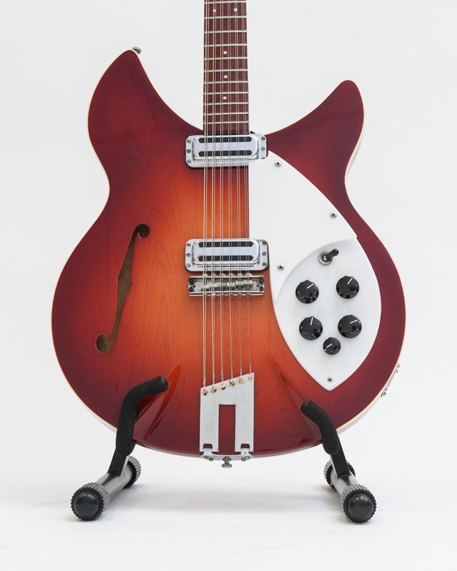 A guitar is sitting on a stand against a white background