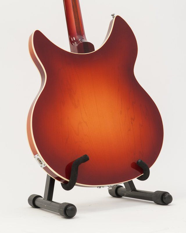 The back of a guitar is shown on a stand